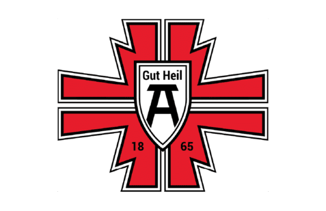 Logo mit rotem Kreuz, schwarzem Schild und der Aufschrift &bdquo;Gut Heil&ldquo; sowie der Jahreszahl &bdquo;1865&ldquo;.